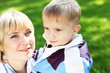 Young mother with her son in summer park