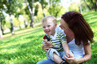 Photo: Young mother with her son in summer park Young mother with her son in summer park
