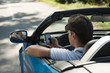 Young man driving his convertible car