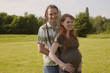 Young Couple on a meadow awaiting a Baby