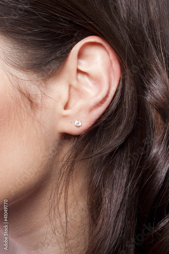 Photo: Young woman ear closeup Young woman ear closeup