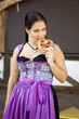German girl wearing typical bavarian clothes eating breze