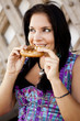 German girl wearing typical bavarian clothes eating breze
