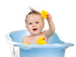 charming baby having bath in blue tub and playing with soap bubb