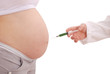 The doctor holds a syringe near the abdomen of pregnant woman
