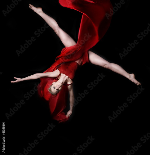 Foto: Young woman gymnast on black background Young woman gymnast on black background