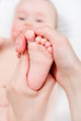 Mother massaging her baby girl
