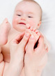 Mother massaging her baby girl