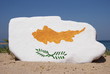Cyprus flag painted on a stone with sand background