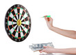 A hand throwing a dart at a sticker on darts on white background A hand throwing a dart at a sticker on darts on white background