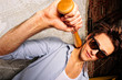 Portrait of young guy with bat leaning on the wall