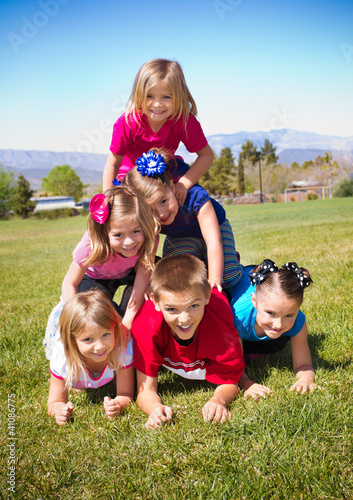 Photo: Cute Kids Building a Human Pyramid outdoors Cute Kids Building a Human Pyramid outdoors
