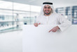 arabian business man pointing at a blank white sign