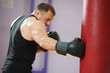 Foto: boxer man at boxing training with heavy bag boxer man at boxing training with heavy bag