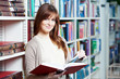 young adult student selecting book in library