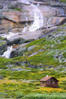 Wooden cottage with waterfall in wild nature Wooden cottage with waterfall in wild nature