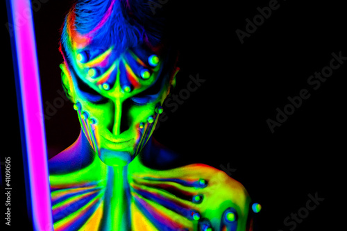 Photo: Man with fluorescent bodyart. Black background. Studio shot Man with fluorescent bodyart. Black background. Studio shot