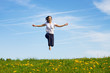 Foto: smiling young girl jumping against blue sky smiling young girl jumping against blue sky