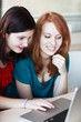 Two female college students working on a laptop computer during Two female college students working on a laptop computer during