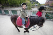 enfant faisant du poney