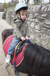 enfant faisant du poney