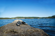Pair of black beach sandals on the rock beside a reservoir Pair of black beach sandals on the rock beside a reservoir