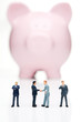 Piggy bank with business figures shaking hands