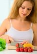 Photo: young woman, a housewife preparing dinner vegetable salad in the young woman, a housewife preparing dinner vegetable salad in the