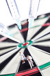 Syringes stuck in a dartboard with medical figures.