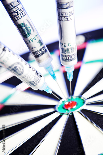 Photo: Syringes with 100 dollars inside, stuck in a dartboard Syringes with 100 dollars inside, stuck in a dartboard