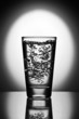Glass of water on reflective surface