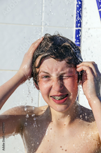 Photo: boy has fun unter the pool shower boy has fun unter the pool shower