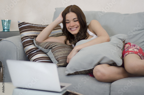Photo: Cute girl watching TV on her laptop Cute girl watching TV on her laptop