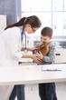 Young vet helping little boy with rabbit