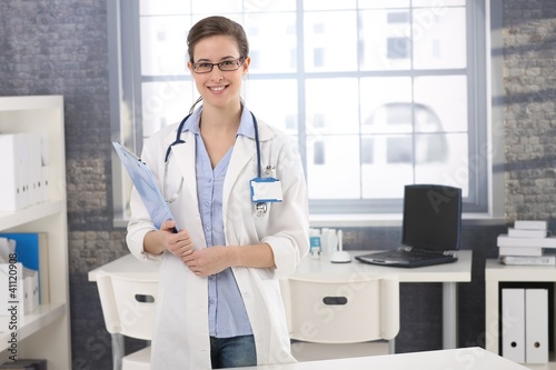 Photo: Happy young female doctor in office Happy young female doctor in office