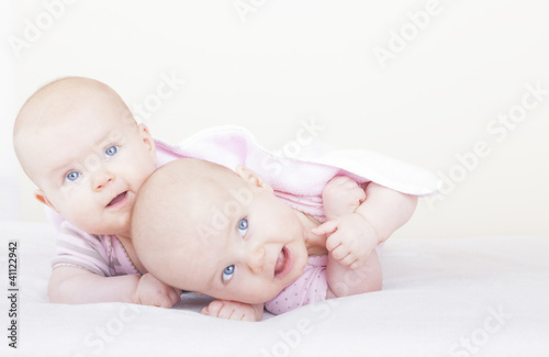Photo: identical twin sister on bed learning how to crawl identical twin sister on bed learning how to crawl