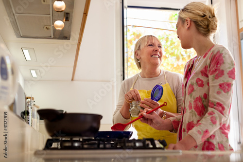 Photo: mom and daughter cooking in home kitchen mom and daughter cooking in home kitchen
