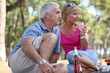 a mid age couple having a picnic in a pine forest