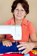 Hispanic woman working on a sewing machine Hispanic woman working on a sewing machine