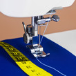 Sewing machine, thread and a yellow measuring tape Sewing machine, thread and a yellow measuring tape