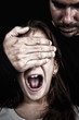 Child screaming while a man covers her eyes