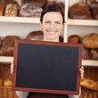 bäckereiverkäuferin zeigt leere tafel