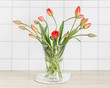 Vase mit einem Blumenstrauß roter Tulpen.