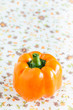 Orange Paprika auf Serviette mit Blümchenmuster.