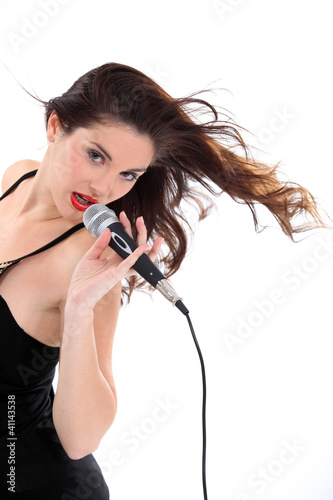Foto: Brunette singing into microphone Brunette singing into microphone