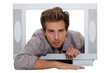 Young man trying to climb out of a tv set Young man trying to climb out of a tv set