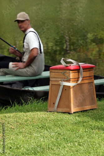 Photo: gentleman seated in boat fishing gentleman seated in boat fishing