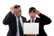 Two businessmen with shocked expression on face