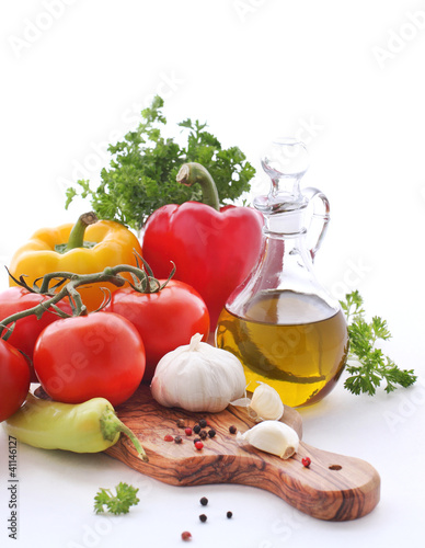 Photo: Olive oil, tomatoes, peppers and herbs on a white background Olive oil, tomatoes, peppers and herbs on a white background
