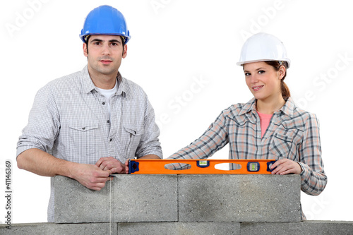 Photo: craftsman and craftswoman erecting a wall craftsman and craftswoman erecting a wall